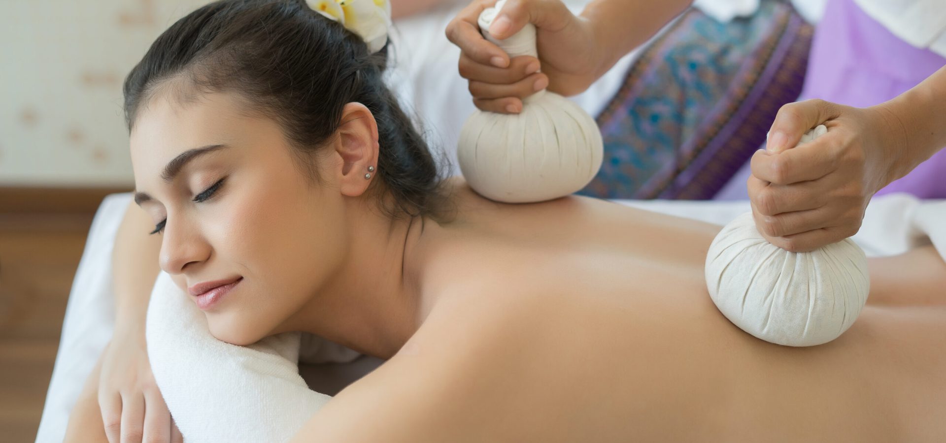 Young beautiful woman relaxing during massage in spa salon.